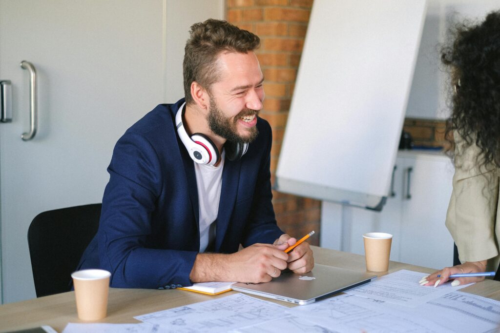 A salesperson sitting at a table talking to a client.